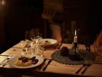 un tavolo in legno con piatti di bicchieri da cibo e vino di Kotatieva Resort a Rovaniemi