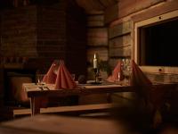 un tavolo con tovaglioli rossi e una candela sopra di Kotatieva Resort a Rovaniemi