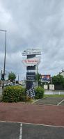 a sign for a restaurant with flowers in front of it at Hotel Le Circuit Le Mans in Le Mans