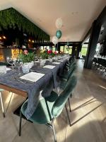 una mesa larga en un restaurante con sillas verdes en Floating Dream, en Fiano