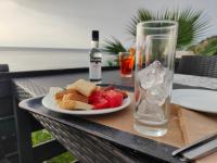 een bord eten en een glas water op een tafel bij Sea & sun view in Agios Stefanos