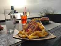 een bord eten met een broodje en frietjes bij Sea & sun view in Agios Stefanos