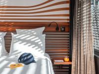 a bed with a pair of scissors on top of it at Hotel OFF Paris Seine in Paris