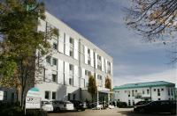 Un edificio blanco con coches aparcados en un estacionamiento. en ateckhotel Kirchheim&#47;Teck, en Kirchheim unter Teck