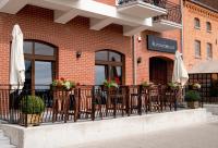 Un balcón de un restaurante con sillas y sombrillas. en Portobello, en Ustka