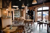 Un restaurante con mesas y sillas en una sala. en Portobello, en Ustka