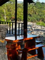ein Holztisch und Bänke auf einer Veranda in der Unterkunft Villa Joglo tepi sungai in Sidemen