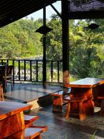 ein Restaurant mit Holztischen und Blick auf den Wald in der Unterkunft Villa Joglo tepi sungai in Sidemen