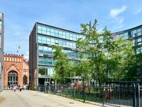 um grande edifício de vidro com árvores em frente em Hotel am Borsigturm em Berlim