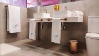 a bathroom with two sinks and towels and a toilet at Hotel Ritual Torremolinos- Adults Only in Torremolinos