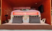 a bedroom with a large bed with an orange wall at Hotel Ritual Torremolinos- Adults Only in Torremolinos