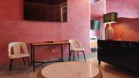 a living room with pink walls and a table and chairs at Hotel Ritual Torremolinos- Adults Only in Torremolinos