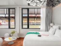 a bedroom with a white bed with a table and windows at Hotel OFF Paris Seine in Paris
