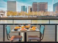 a table with plates of food on a balcony at Hotel OFF Paris Seine in Paris