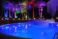 a pool with palm trees lit up at night at HAMILTON Agadir in Agadir