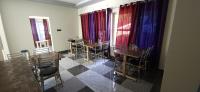 a dining room with tables and chairs and windows at Hotel HBH Himalaya's Beautiful Hills in Uttarkāshi