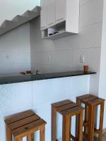 a kitchen with two wooden stools next to a counter at Pousada QUERÊNCIA FRANCÊS in Marechal Deodoro