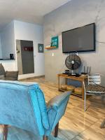 a living room with a blue couch and a tv at Pousada QUERÊNCIA FRANCÊS in Marechal Deodoro