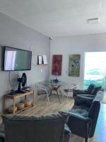a living room with a tv and a table and chairs at Pousada QUERÊNCIA FRANCÊS in Marechal Deodoro
