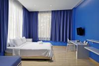 a bedroom with blue walls and a bed and a desk at Beat Hotel Bangkok in Bangkok