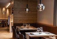 a dining room with tables and chairs and lights at Hotel Laste' in Caldes