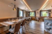a dining room with tables and chairs and windows at Hotel Laste' in Caldes