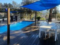 einen Tisch mit einem blauen Regenschirm neben einem Pool in der Unterkunft Spa Ibiza Dosrius in Canyamás