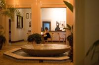 Eine Frau sitzt an einem Tisch in einem Raum mit einer großen Badewanne. in der Unterkunft Vipingo Ridge limited in Kilifi