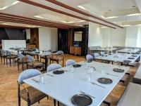 Una sala de conferencias con mesas y sillas y un podio. en Hotel Majestic By NxtJen Hospitality, en Silvassa