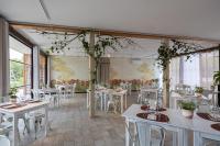 a restaurant with white tables and white chairs at Agriturismo Sadira in Calusco dʼAdda