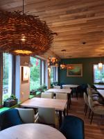 un ristorante con soffitti in legno, tavoli e sedie di Gintarautojai a Palanga