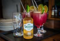 a table with two glasses and a bottle of drink at AVO Boutique Hotel in Dikoni