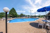 una piscina con una mesa y una sombrilla azul en Chester Inn, en Gastonia