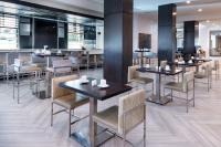 Un restaurante con mesas y sillas y un bar. en Home2 Suites by Hilton Columbia Downtown, en Columbia