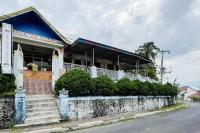 un edificio en una calle con una pared de piedra en Hotel Harapan Isyes Syariah RedPartner, en Parapat