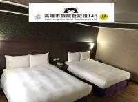2 camas en una habitación de hotel con un cartel encima en Long Siang Hotel, en Kaohsiung