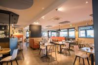 un restaurant avec des tables et des chaises dans une salle dans l'établissement Brit Hotel La Rochelle Périgny, à Périgny