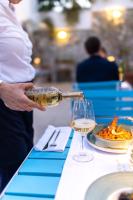 uma pessoa a derramar vinho num copo sobre uma mesa em Boutique Hotel Blanc & Bleu - Capitano em Herceg-Novi