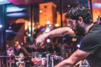 a man standing at a bar pouring a glass of wine at Timeout Heritage Hotel Zagreb in Zagreb