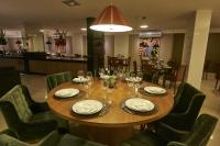 un tavolo in un ristorante con piatti e bicchieri da vino di Alfa Hotel a Viçosa