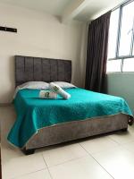 Un dormitorio con una cama con un edredón verde. en Hotel Riviera Confort, en Pasto