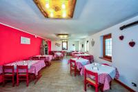 un restaurante con paredes rojas, mesas y sillas rojas en Locanda e Ristoro MALETTO, en Carema