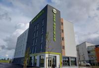 Un edificio con un reloj en el costado. en B&amp;B HOTEL Orléans Saran, en Saran