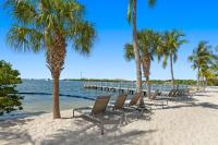 eine Reihe von Stühlen am Strand mit Palmen in der Unterkunft Beachside Resort &amp; Residences in Key West