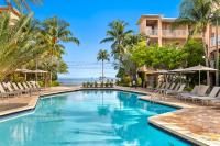 ein Swimmingpool mit Stühlen und Palmen in der Unterkunft Beachside Resort &amp; Residences in Key West