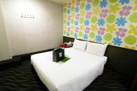 a bedroom with a large white bed with flowers on the wall at LIHO Hotel Tainan in Tainan