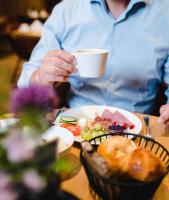 ミュンスターにあるATLANTIC Hotel Münsterのコーヒーを飲みながら座る男