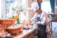 a chef preparing food in a restaurant kitchen at Risemount Premier Resort Da Nang in Da Nang
