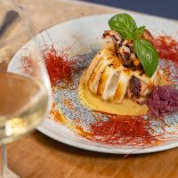 Un plato de comida en una mesa con una copa de vino. en Selinunte Boutique Hotel, en Marinella di Selinunte
