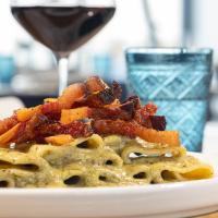 Un plato de pasta con tocino y una copa de vino en Selinunte Boutique Hotel, en Marinella di Selinunte